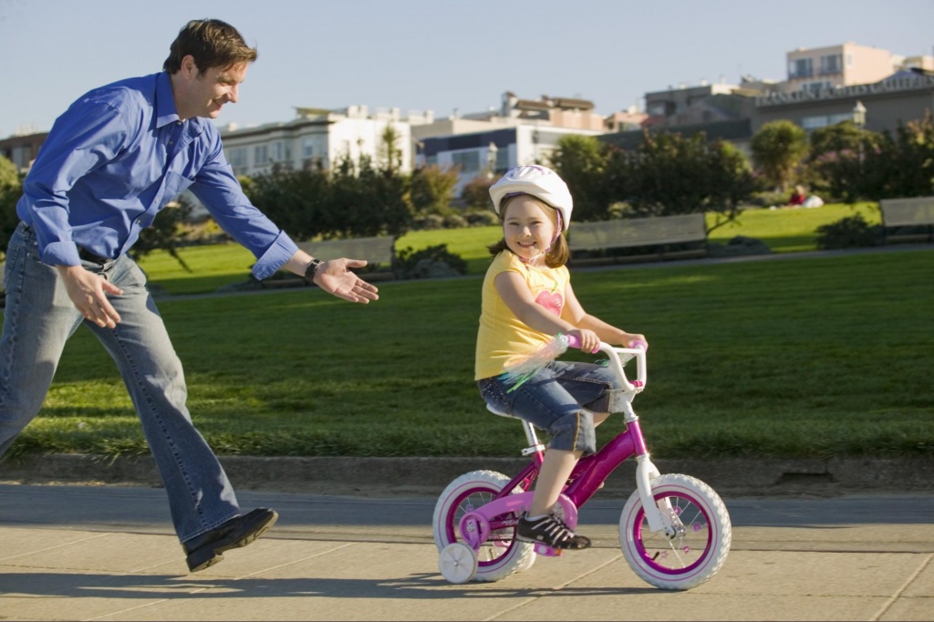 Ребенка учат кататься на велосипеде
