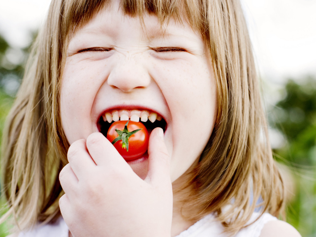 Девочка есть помидор