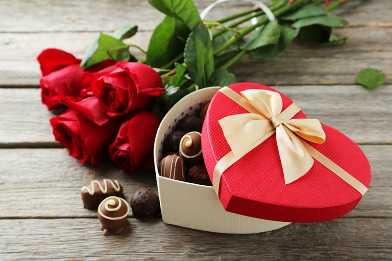 Коробка конфет в виде сердца и букет роз
